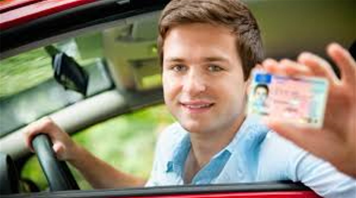 رجل يجلس في السيارة ويحمل شهادة قيادة تركية - تحويل رخصة القيادة إلى رخصة تركية