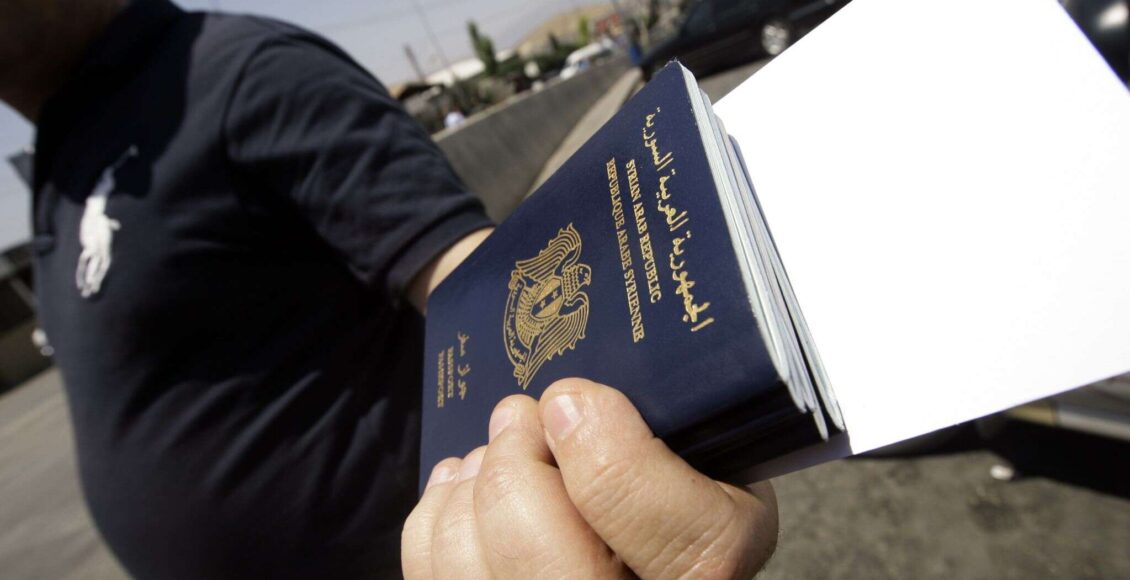 شخص يحمل مجموعة جوازات سفر - شروط دخول السوريين إلى لبنان