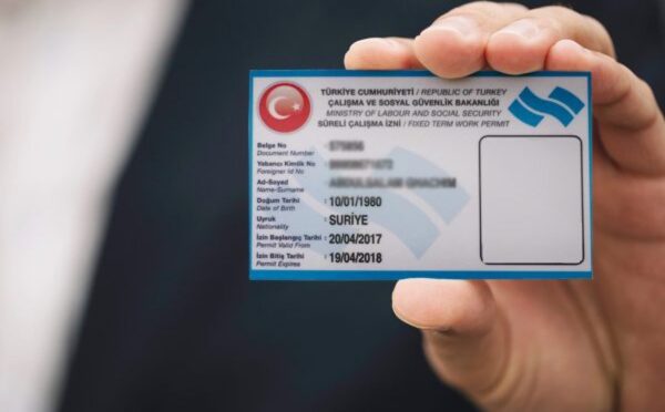 شخص يحمل بطاقة اذن العمل في تركيا من خلال الاستثمار