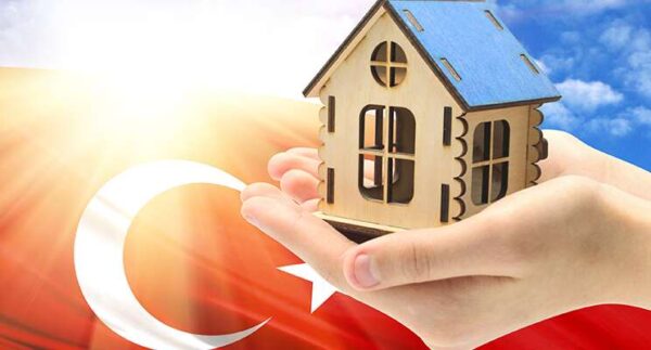 مجسم لمنزل وضع على راحة اليد وعلم تركيا التملك العقاري في تركيا للأجانب